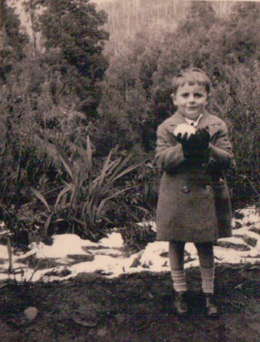 Barry Humphries as a little boy in Australia clutching a rare snowball